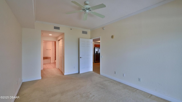 unfurnished bedroom featuring stainless steel fridge, ornamental molding, light colored carpet, ceiling fan, and ensuite bath