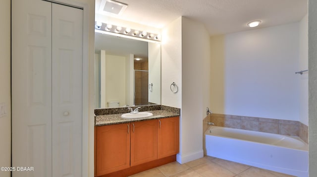 full bathroom with toilet, a textured ceiling, vanity, plus walk in shower, and tile patterned flooring