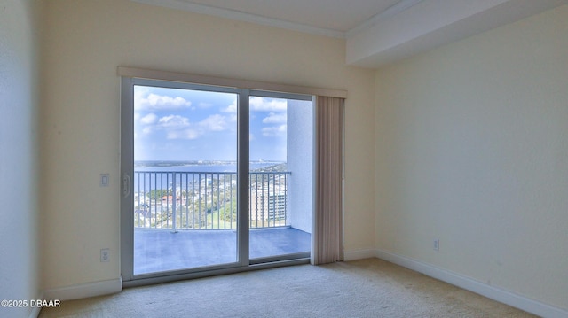 spare room with crown molding, a water view, and carpet floors