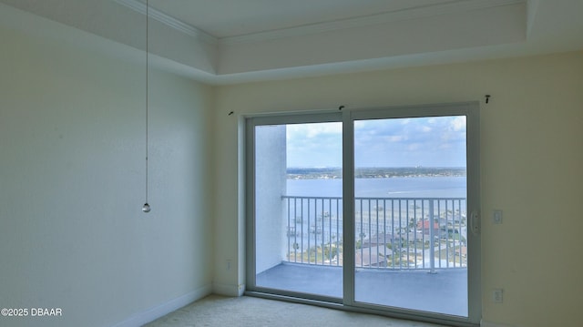 unfurnished room with carpet floors, crown molding, plenty of natural light, and a water view