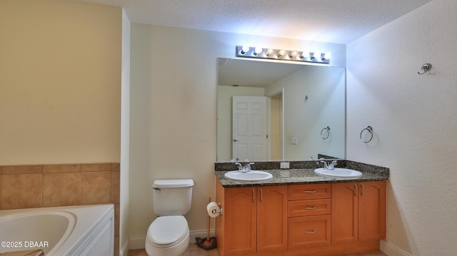 bathroom with vanity, toilet, a bathing tub, and a textured ceiling