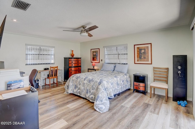 1300 Oak Forest Dr, Ormond Beach, FL 32174 - bedroom with light wood-style floors, crown molding, a textured ceiling, ceiling fan, and baseboards