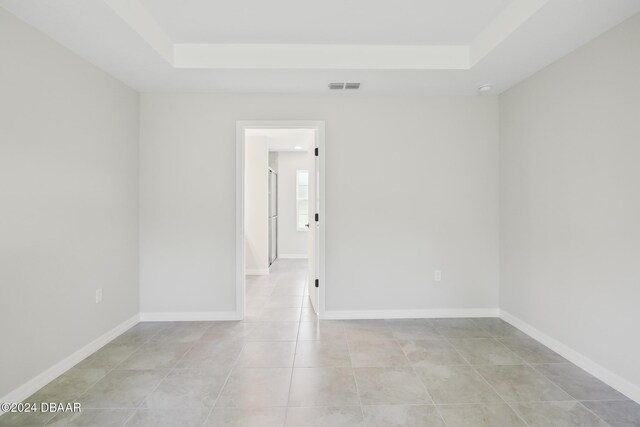 30 Peppercorn Ln, Palm Coast, FL 32164 - empty room with a raised ceiling, light tile patterned flooring, and baseboards