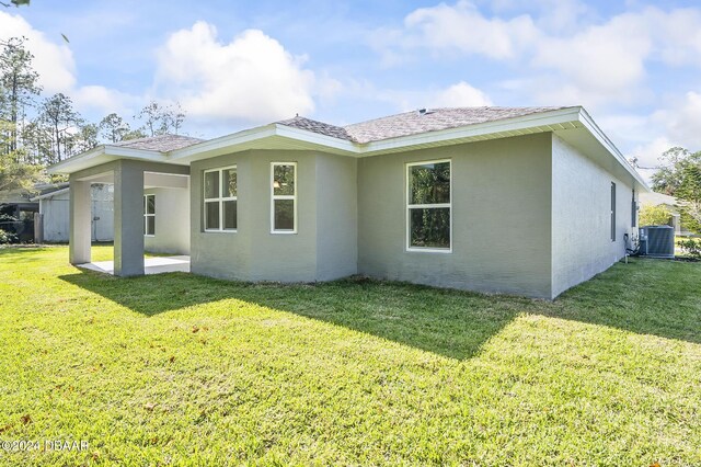 30 Peppercorn Ln, Palm Coast, FL 32164 - rear view of property featuring central AC unit, a lawn, a patio, and stucco siding