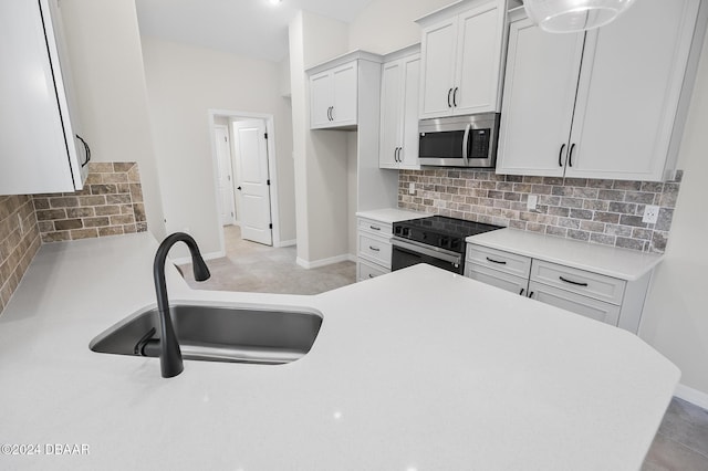 30 Peppercorn Ln, Palm Coast, FL 32164 - kitchen with stainless steel microwave, a sink, range with electric stovetop, decorative backsplash, and light countertops