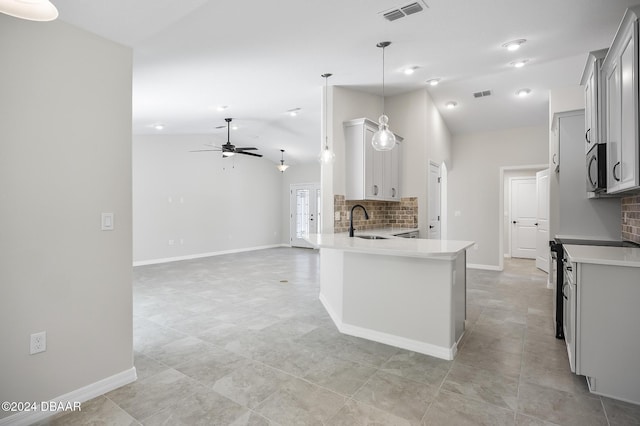 30 Peppercorn Ln, Palm Coast, FL 32164 - kitchen featuring ceiling fan, decorative backsplash, vaulted ceiling, a sink, and light countertops