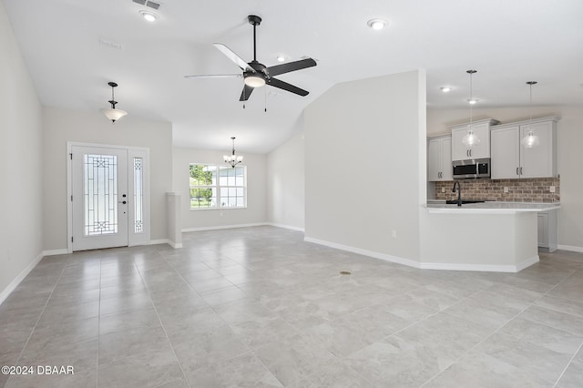 30 Peppercorn Ln, Palm Coast, FL 32164 - unfurnished living room featuring ceiling fan, lofted ceiling, a chandelier, light tile patterned floors, and baseboards