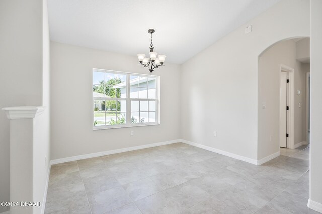 30 Peppercorn Ln, Palm Coast, FL 32164 - spare room featuring arched walkways, a chandelier, light tile patterned floors, and baseboards