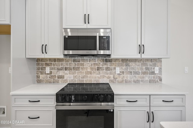 30 Peppercorn Ln, Palm Coast, FL 32164 - kitchen featuring stainless steel microwave, range with electric stovetop, light countertops, white cabinetry, and tasteful backsplash