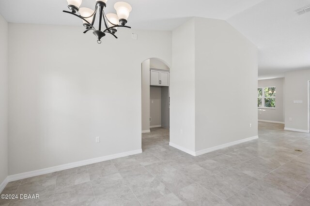 30 Peppercorn Ln, Palm Coast, FL 32164 - unfurnished room with arched walkways, a chandelier, light tile patterned floors, and baseboards