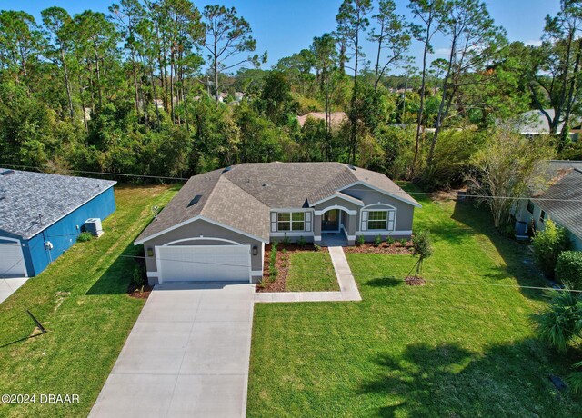 30 Peppercorn Ln, Palm Coast, FL 32164 - ranch-style home featuring concrete driveway, a front lawn, stucco siding, and an attached garage