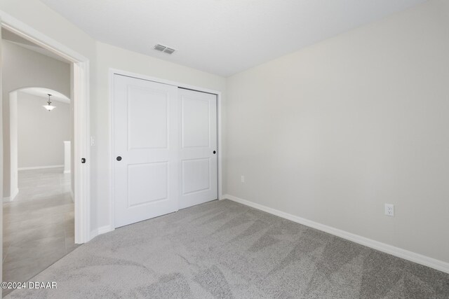 30 Peppercorn Ln, Palm Coast, FL 32164 - unfurnished bedroom featuring arched walkways, a closet, carpet floors, and baseboards