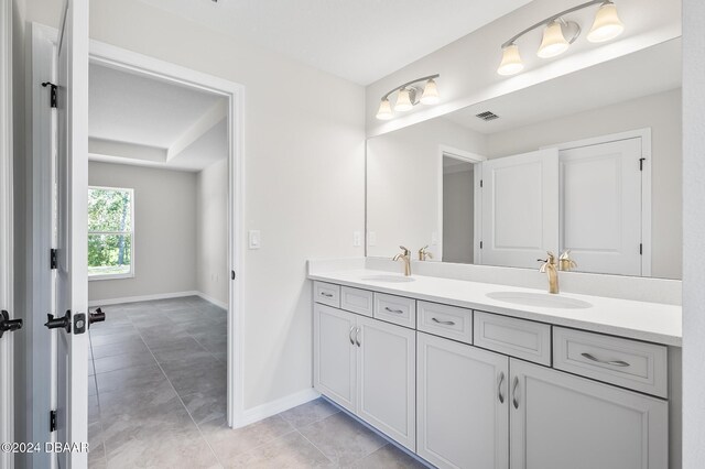 30 Peppercorn Ln, Palm Coast, FL 32164 - bathroom with double vanity, baseboards, and tile patterned flooring