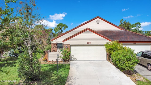 view of front of property featuring concrete driveway, brick siding, and an attached garage