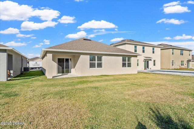 back of house with central AC and a lawn