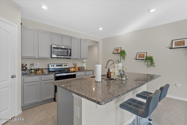 kitchen with gray cabinets, sink, appliances with stainless steel finishes, and dark stone counters