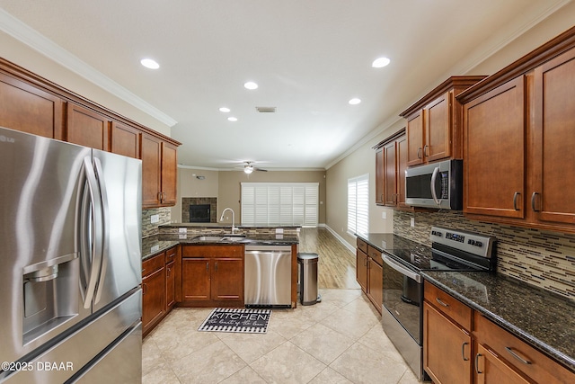kitchen featuring ornamental molding, ceiling fan, a sink, appliances with stainless steel finishes, and backsplash
