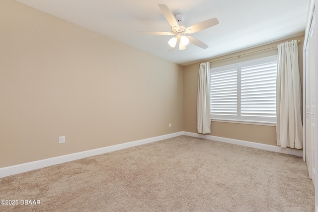 empty room with baseboards, ceiling fan, and carpet