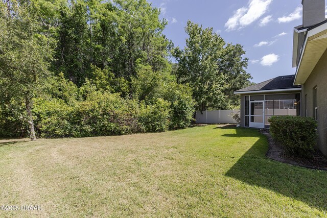 view of yard featuring fence and a sunroom
