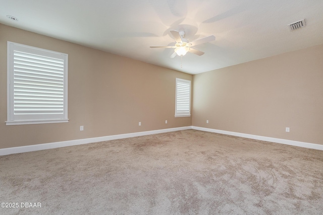unfurnished room with carpet floors, ceiling fan, visible vents, and baseboards