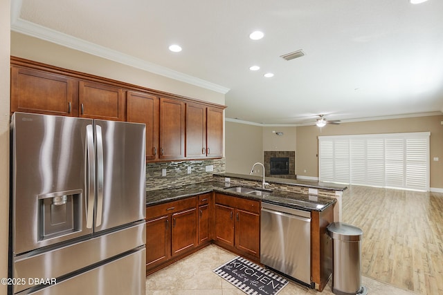 kitchen with visible vents, ornamental molding, ceiling fan, a sink, and stainless steel appliances