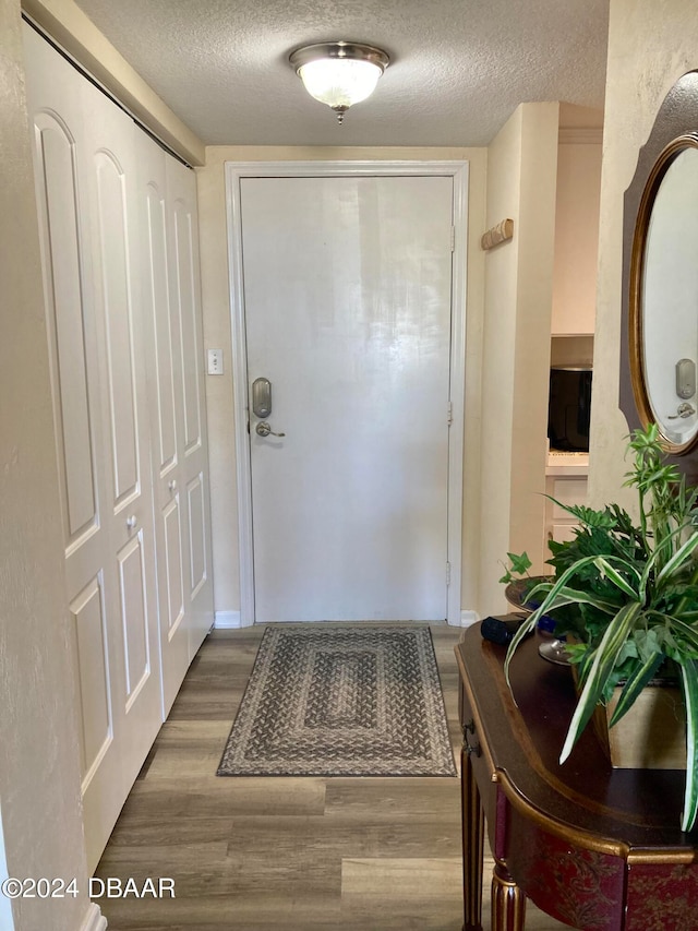 entryway featuring hardwood / wood-style flooring and a textured ceiling