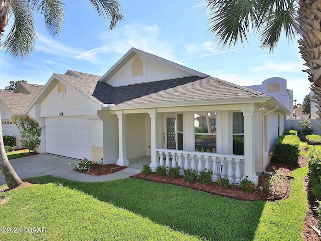 view of front facade with covered porch, a garage, and a front lawn