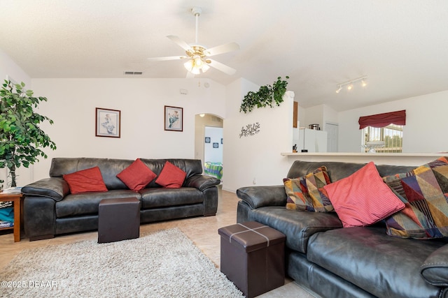 living room with arched walkways, visible vents, ceiling fan, and vaulted ceiling