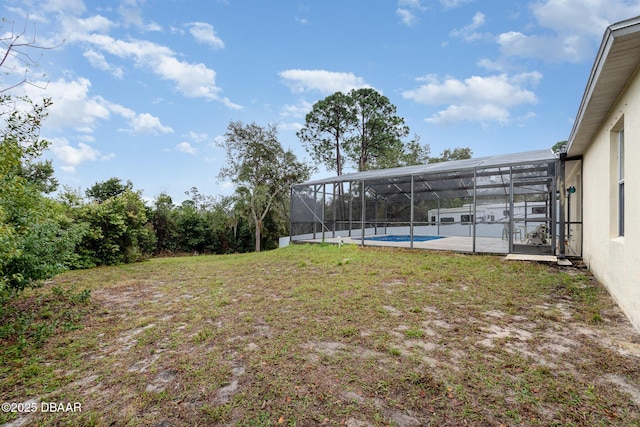 view of yard featuring an outdoor pool, glass enclosure, and a patio area