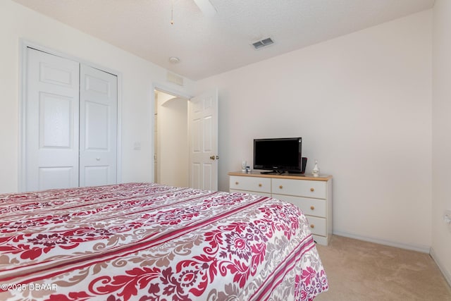 bedroom featuring visible vents, a ceiling fan, a textured ceiling, baseboards, and light colored carpet