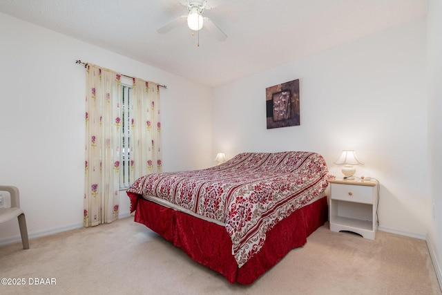 bedroom with light carpet, a ceiling fan, and baseboards