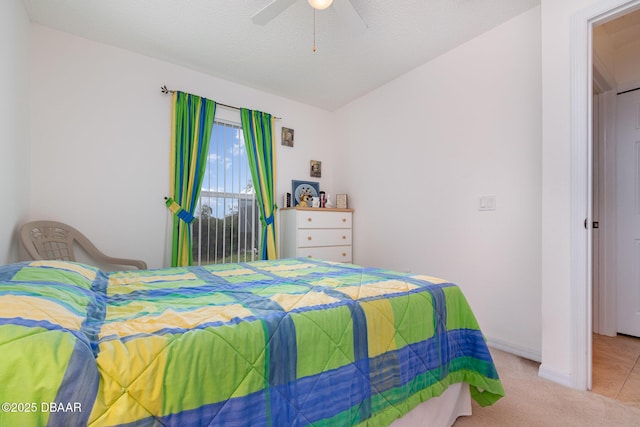 bedroom with a ceiling fan, a textured ceiling, carpet flooring, baseboards, and vaulted ceiling