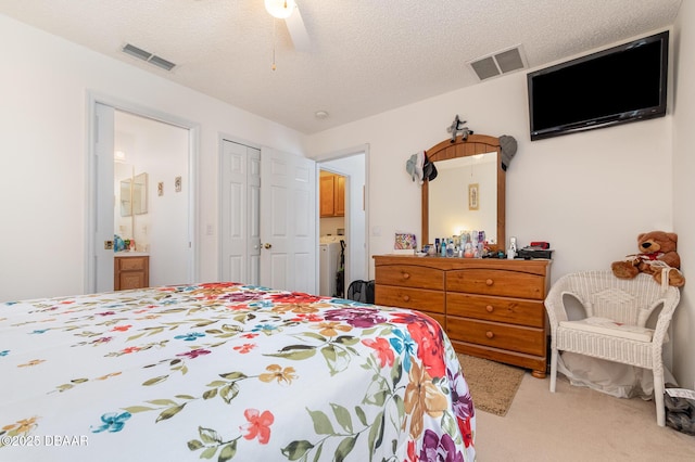 carpeted bedroom with visible vents, a textured ceiling, connected bathroom, and a ceiling fan