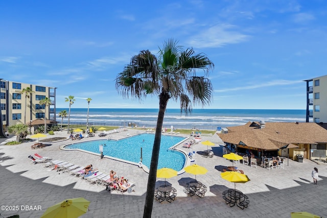 community pool featuring a patio area and a water view