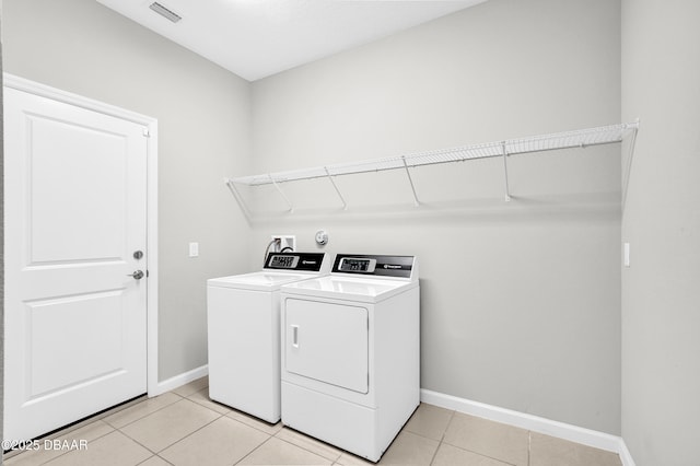 304 Coral Reef Way, Daytona Beach, FL 32124 - laundry room featuring washing machine and clothes dryer, light tile patterned flooring, laundry area, baseboards, and visible vents