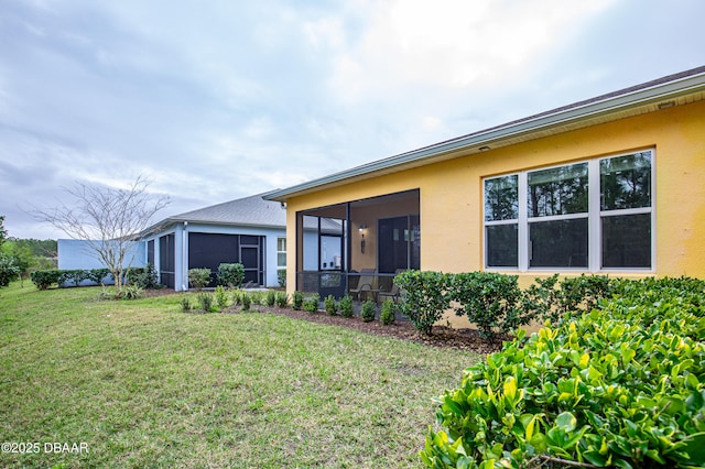 304 Coral Reef Way, Daytona Beach, FL 32124 - rear view of house with a yard, a sunroom, and stucco siding