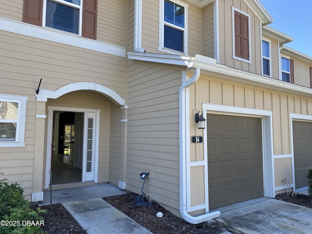 view of exterior entry featuring board and batten siding and an attached garage