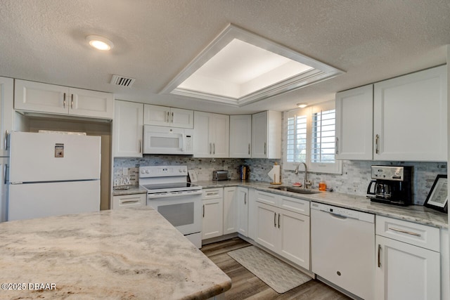 kitchen featuring white cabinetry, sink, a textured ceiling, and white appliances