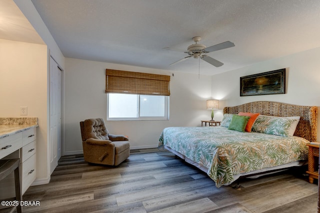 bedroom with a textured ceiling, wood-type flooring, a closet, and ceiling fan