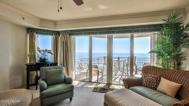 living room featuring plenty of natural light, a water view, and ornamental molding