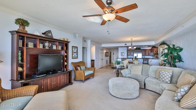 carpeted living room with ceiling fan with notable chandelier, a textured ceiling, and ornamental molding