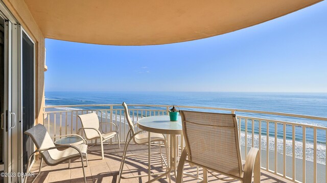 balcony featuring a water view and a view of the beach