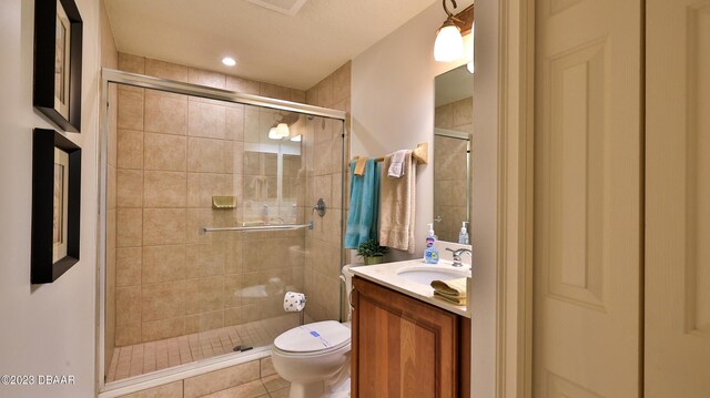 bathroom with tile patterned flooring, vanity, toilet, and a shower with shower door