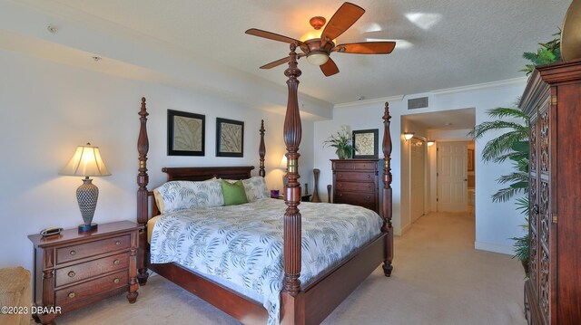 carpeted bedroom with ceiling fan, a textured ceiling, and ornamental molding