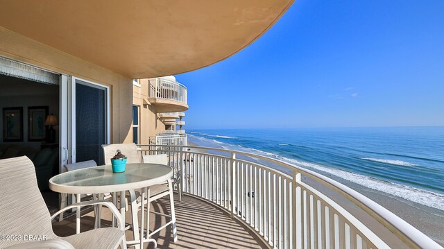 balcony featuring a beach view and a water view