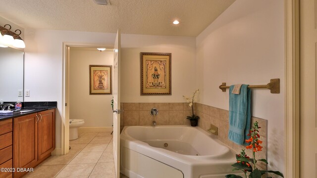 bathroom featuring tile patterned floors, vanity, a textured ceiling, and toilet