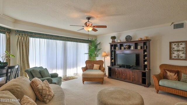 carpeted living room with ceiling fan, a healthy amount of sunlight, crown molding, and a textured ceiling