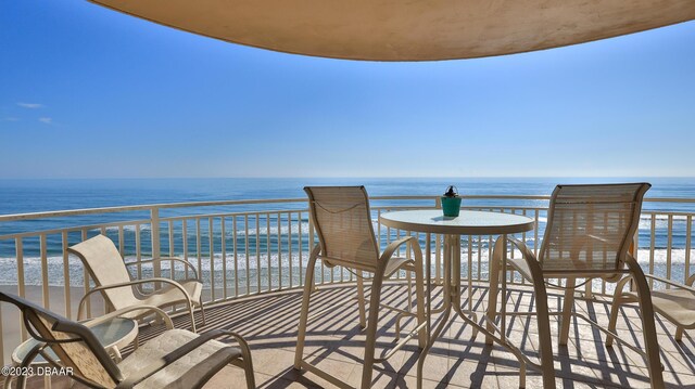 balcony featuring a beach view and a water view