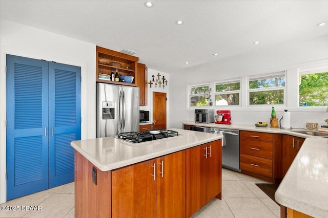 101 Azalea Cir, New Smyrna Beach, FL 32168 - kitchen with appliances with stainless steel finishes, open shelves, light tile patterned floors, light countertops, and a kitchen island