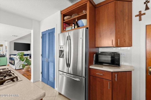 101 Azalea Cir, New Smyrna Beach, FL 32168 - kitchen featuring stainless steel refrigerator with ice dispenser, black microwave, light countertops, backsplash, and light tile patterned floors